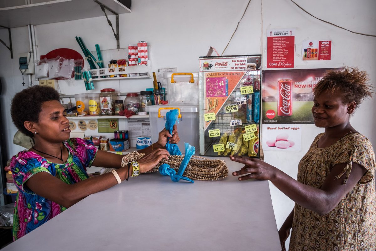 woman buying tabu shell money at a shop