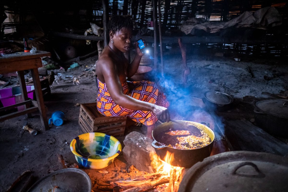 Gaya Bang prepares a meal by torchlight in the early morning. Her family has lost four homes to the sea. 
