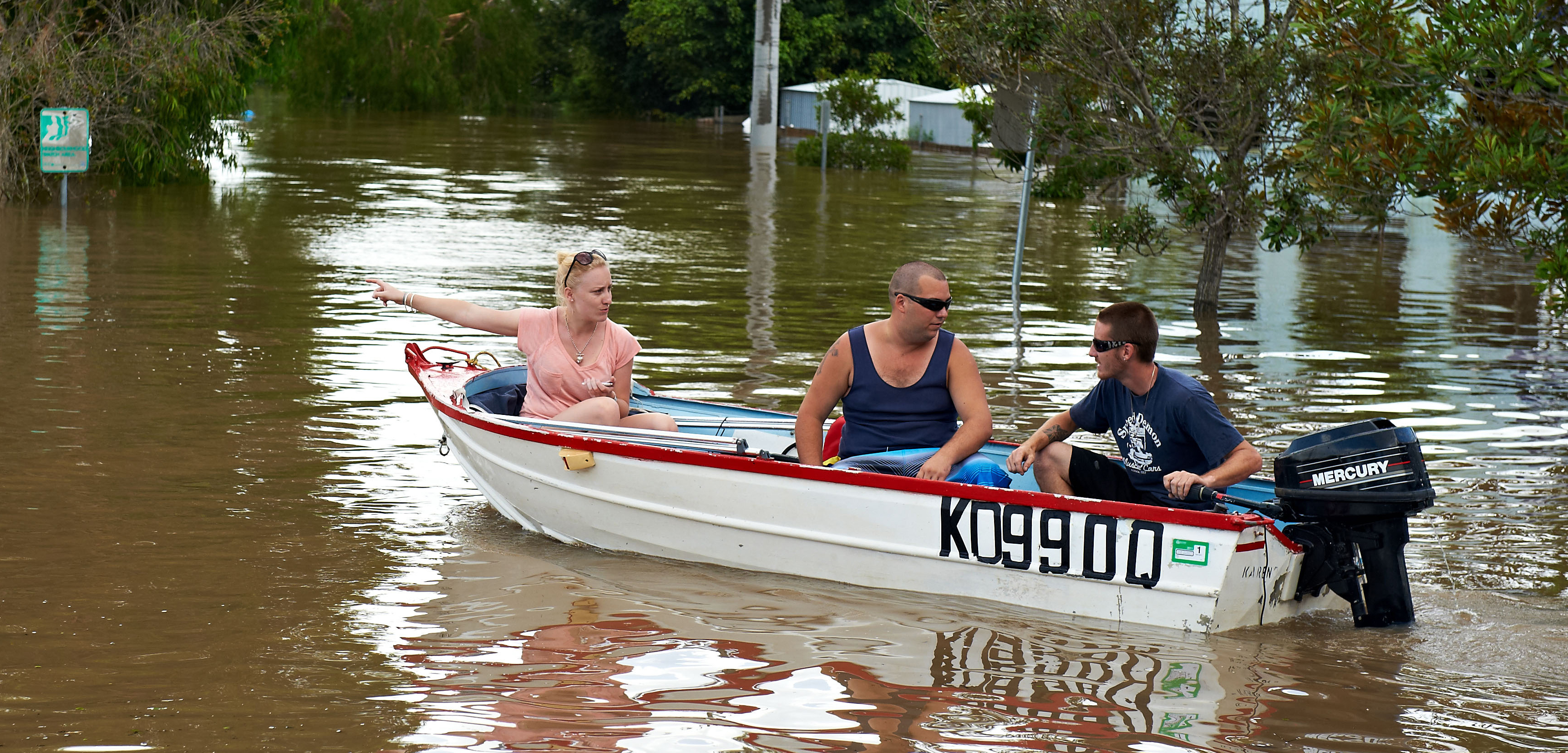 Three people navigate the flood waters in Brisbane, Australia, after heavy flooding hit the region in 2011. Photo by Mark Nemeth/Alamy Stock Photo