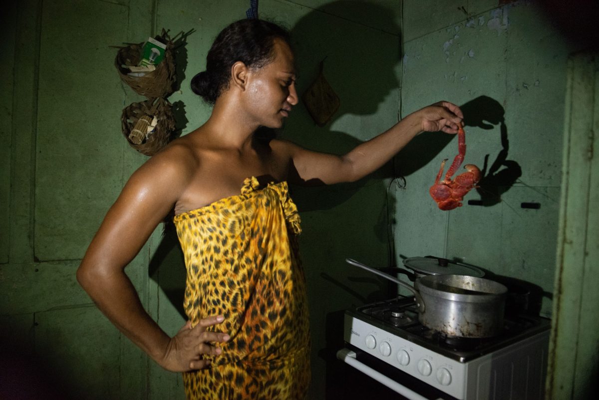 Reretini Viritua prepares a meal of coconut crab in her kitchen, within a home that once belonged to the phosphate mine’s director