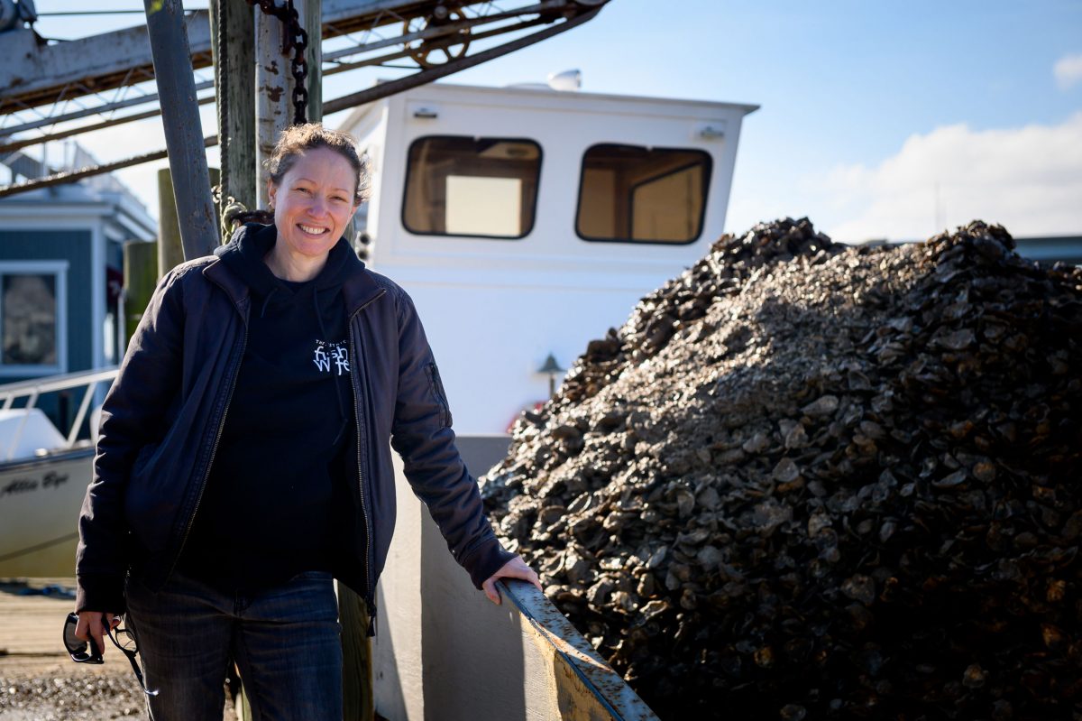 Fiona Lewis poses next to a mound of oyster spat