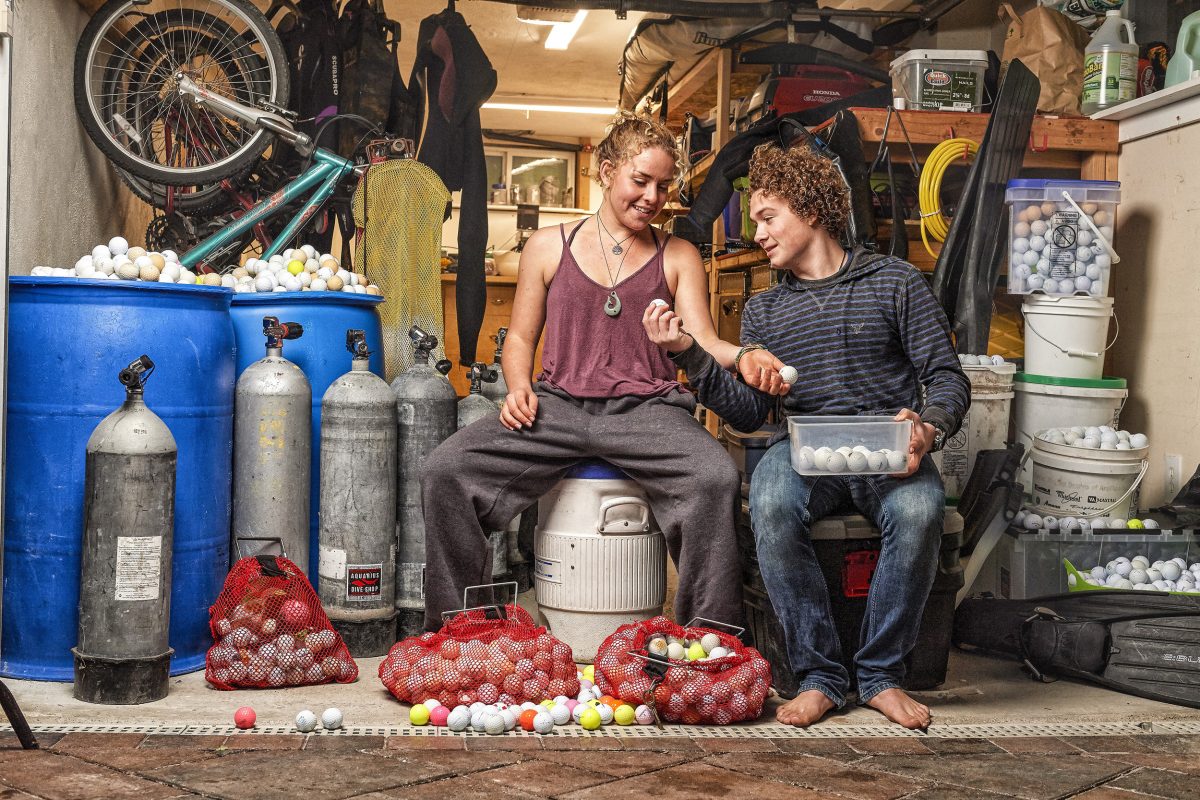 Alex Weber and Jack Johnston inspect some of the over 20,000 golf balls they’ve collected from the ocean and stored in Weber’s garage. Photo by Robert Beck /Sports Illustrated/Getty Images