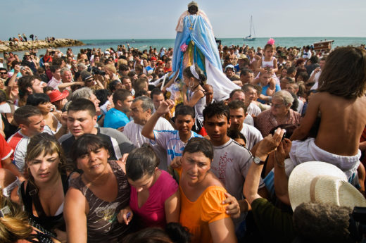 Draped in fabrics that were gifted to her, the statuette of Black Sara, patron saint of the Gypsy people, is carried to the sea in Saintes-Maries-de-la-Mer, France, for her annual dip. Photo by Atlantide Phototravel/Corbis