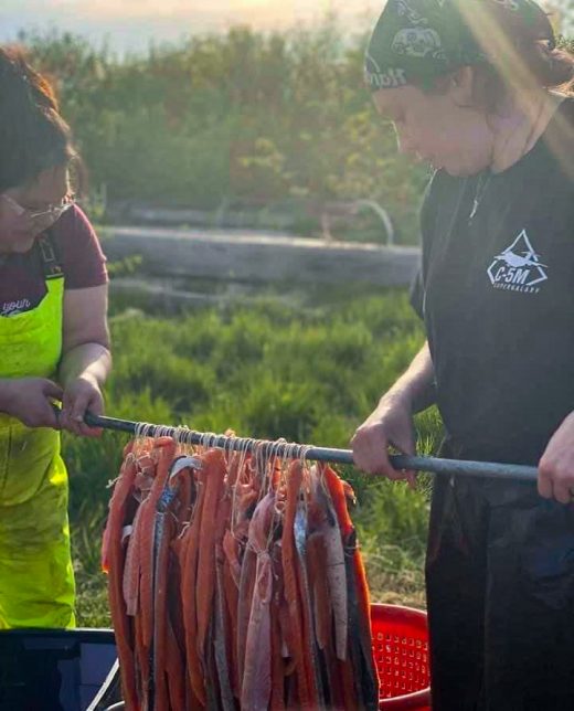 Jaclyn Christensen (left) and Tisha Kalmakoff dip strips of king salmon filets into a brine in preparation for the smokehouse. Photo courtesy of Jaclyn Christensen
