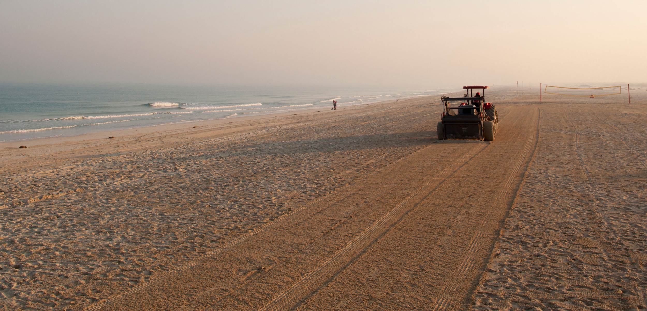 a tractor grooms a beach