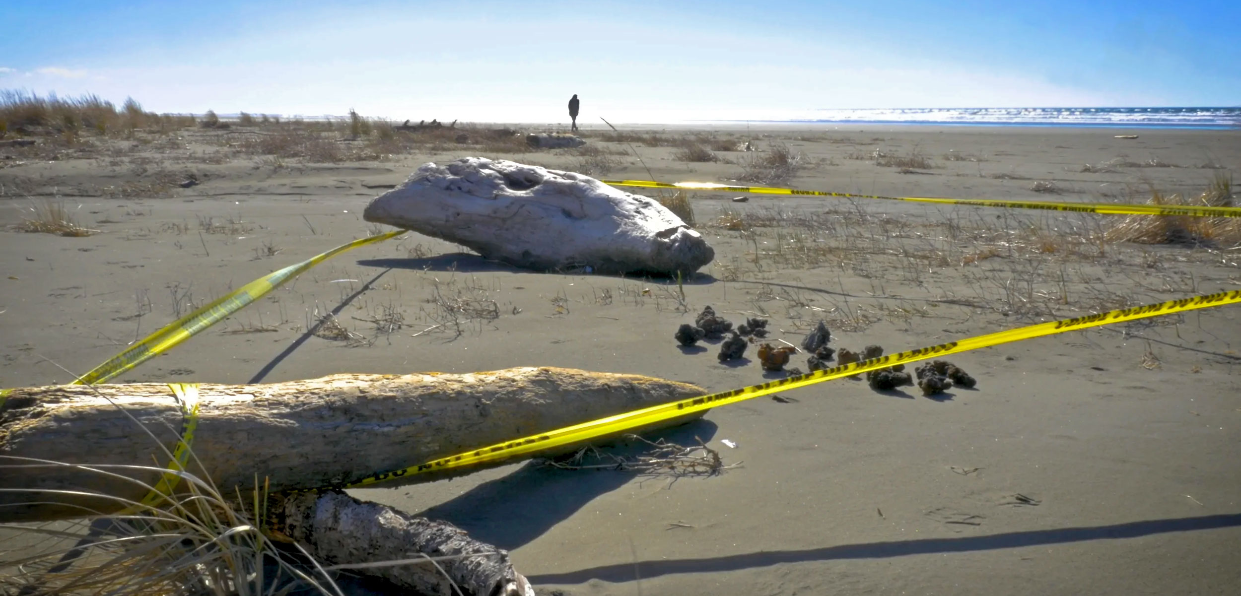 unexploded ordnances behind caution tape on the beach