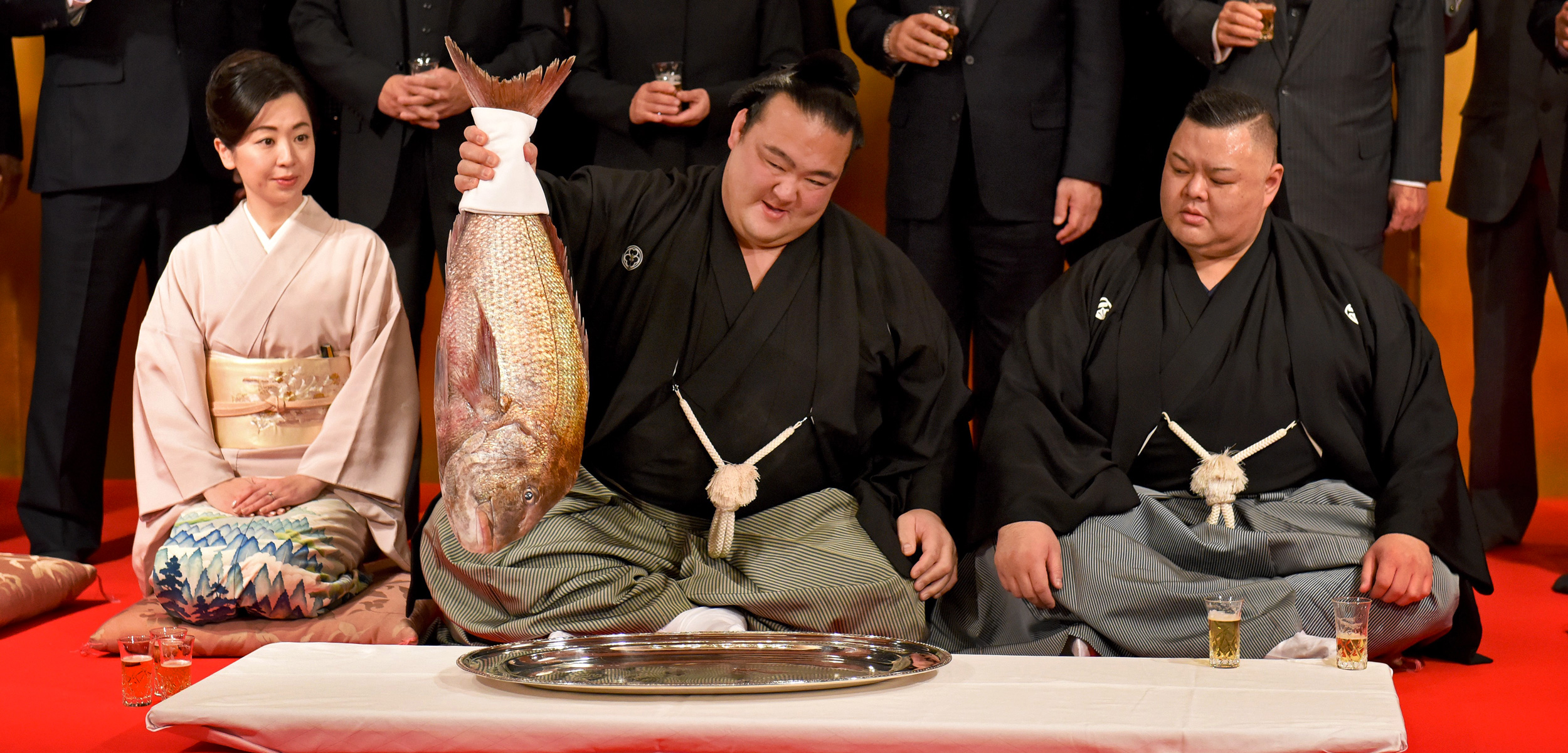 sumo wrestler Kisenosato Yutaka holds up a red seabream