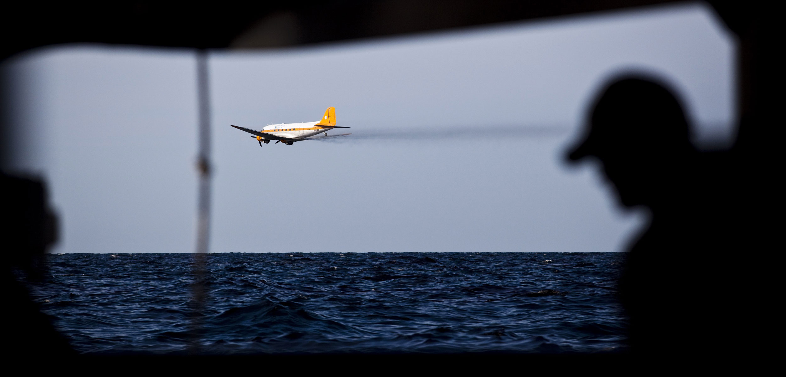 a plane sprays chemical dispersant over oil coated Gulf of Mexico after the Deepwater Horizon spill