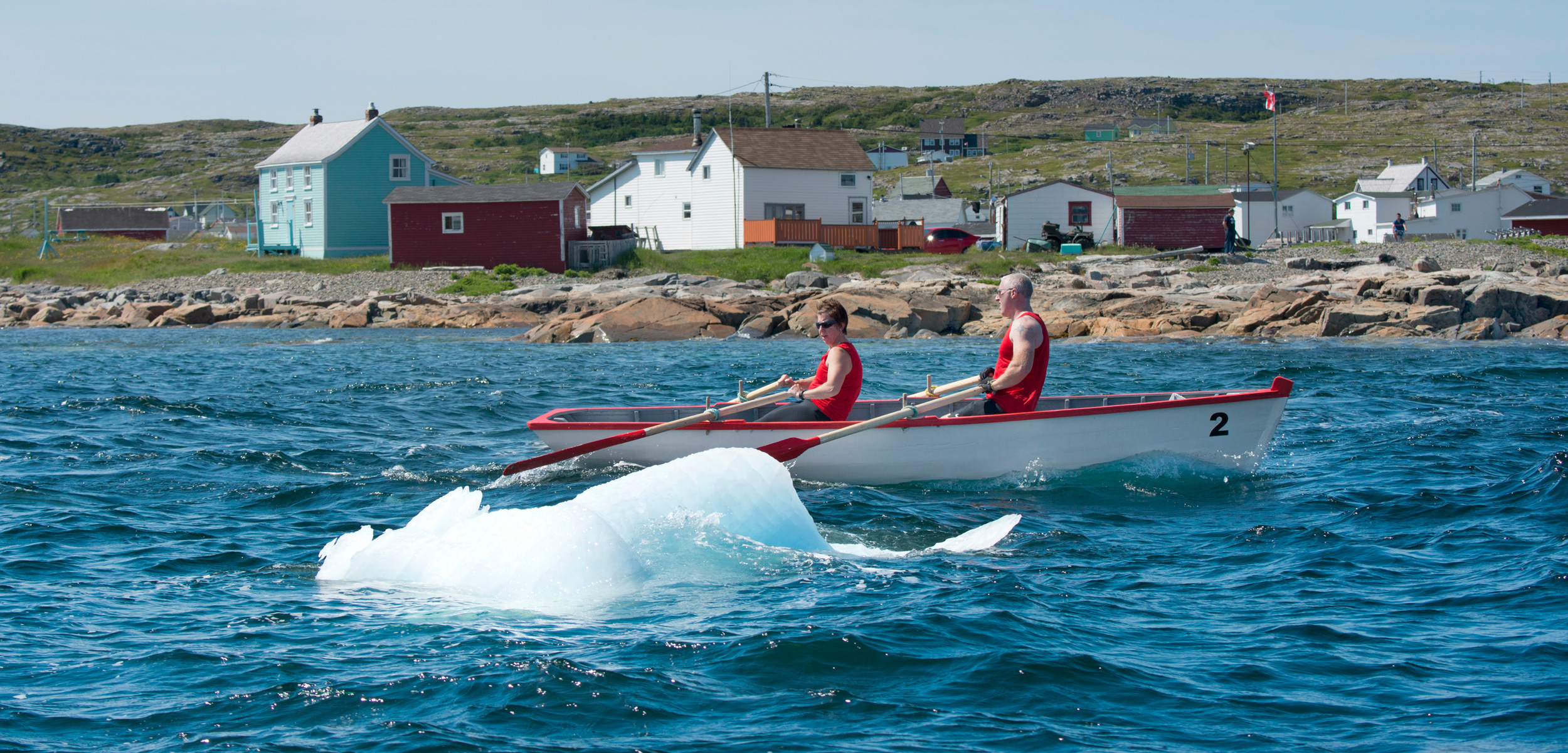 Racers in a punt dodge a small piece of iceberg—known locally as a growler—along the coast of Fogo Island, Newfoundland and Labrador.