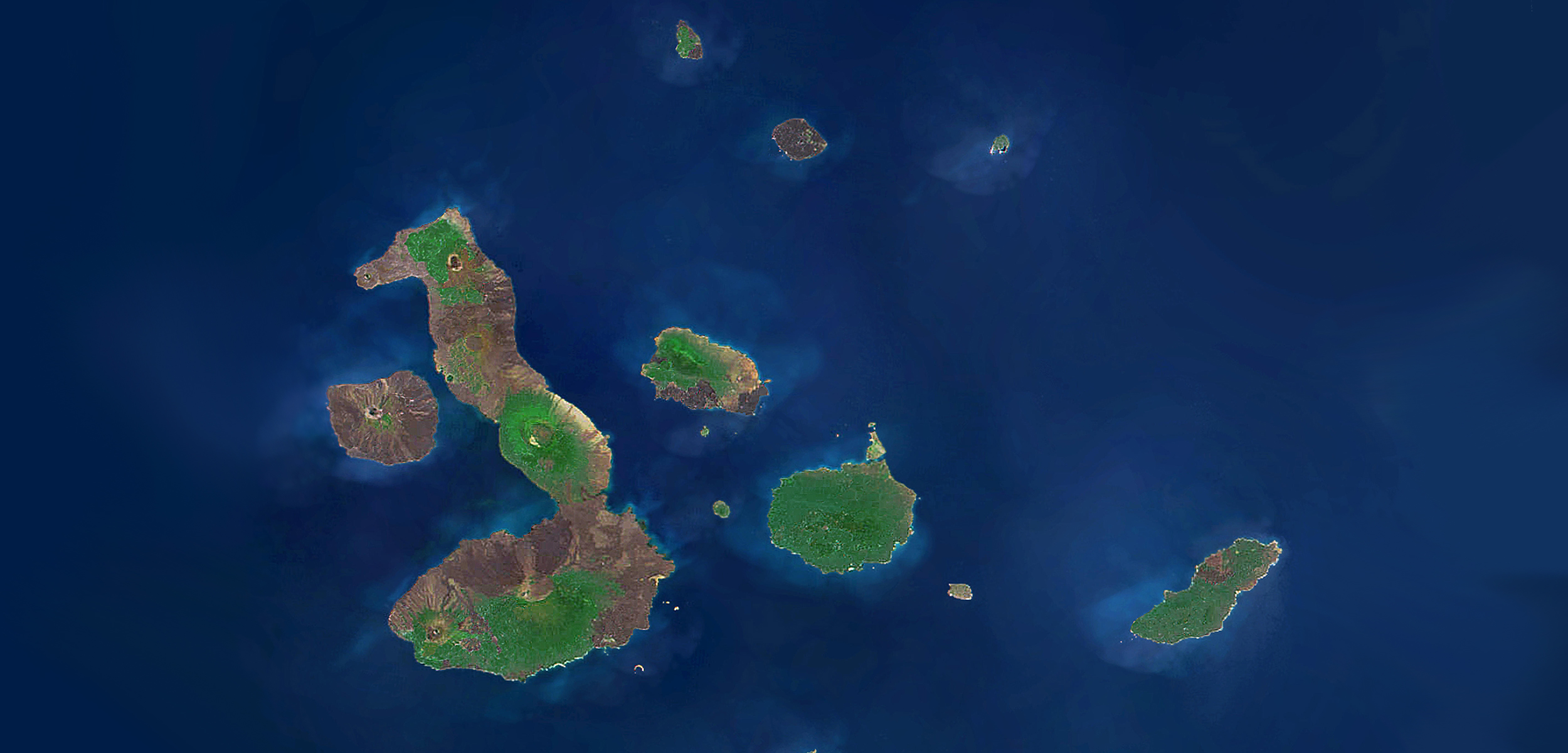 A satellite view of the Galapagos Islands with a dark blue ocean and green islands.