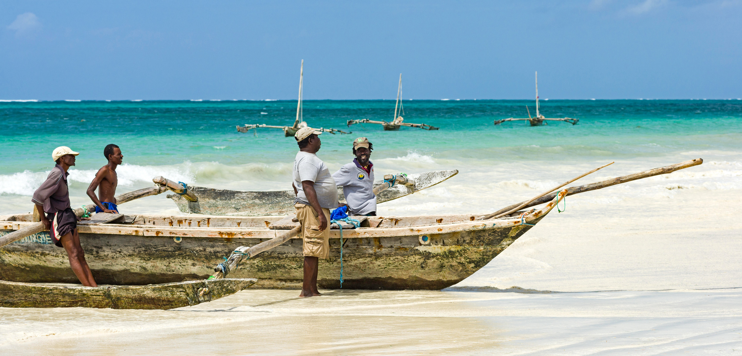 Fisherman with traditional dhow fishing boat at Diani beach, Kenya
