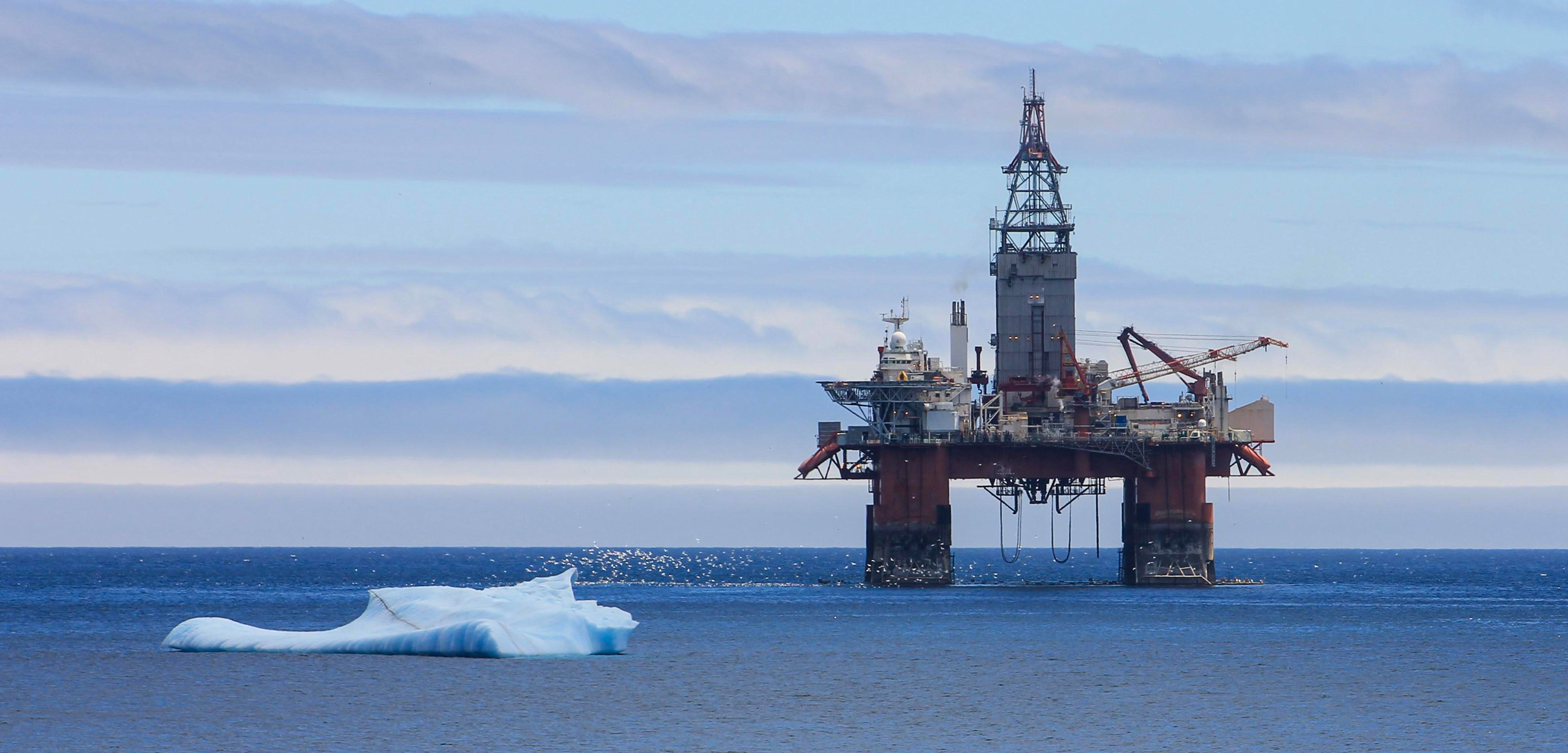 An Iceberg floating by an oil rig, Newfoundland and Labrador, Canada