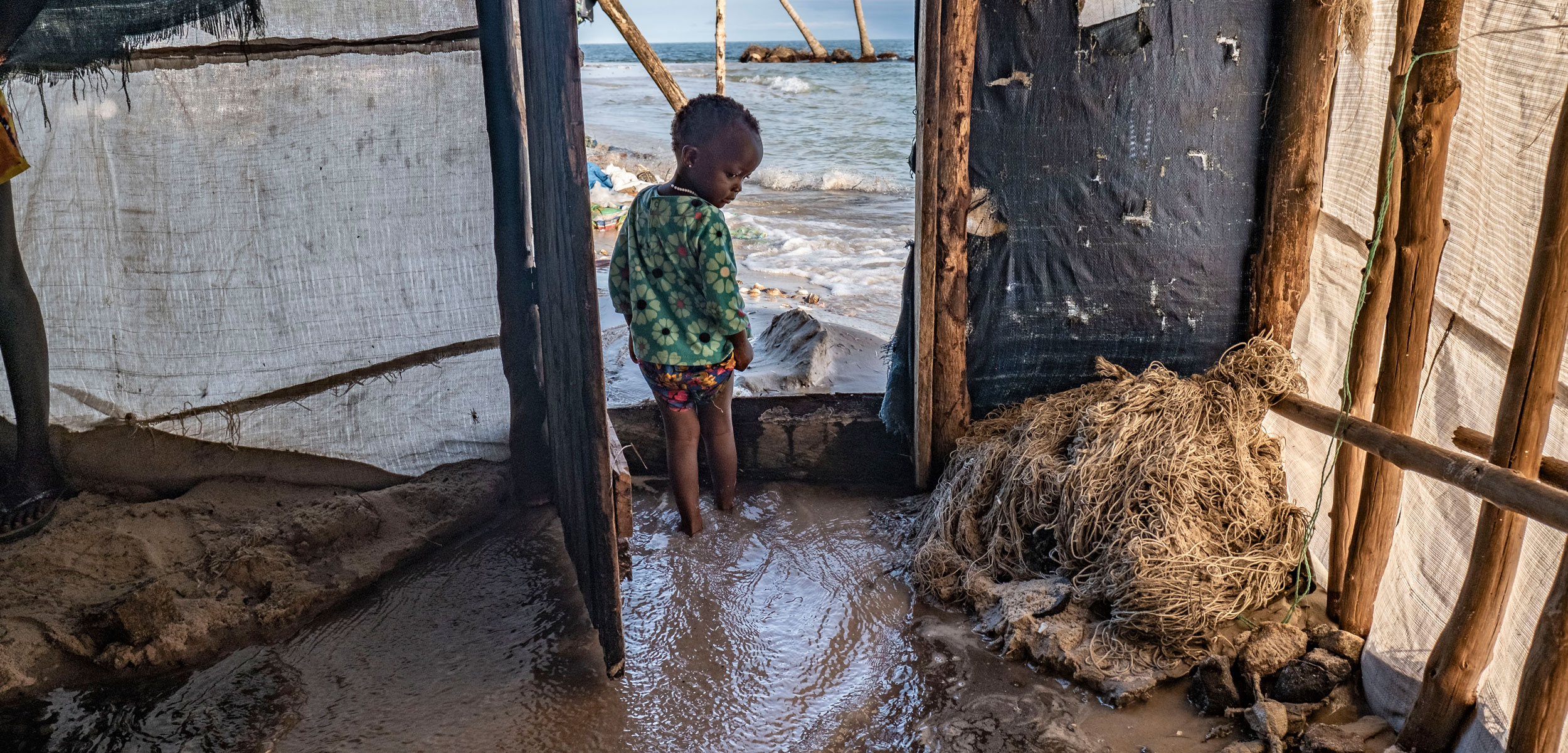 child standing in home as sea water enters
