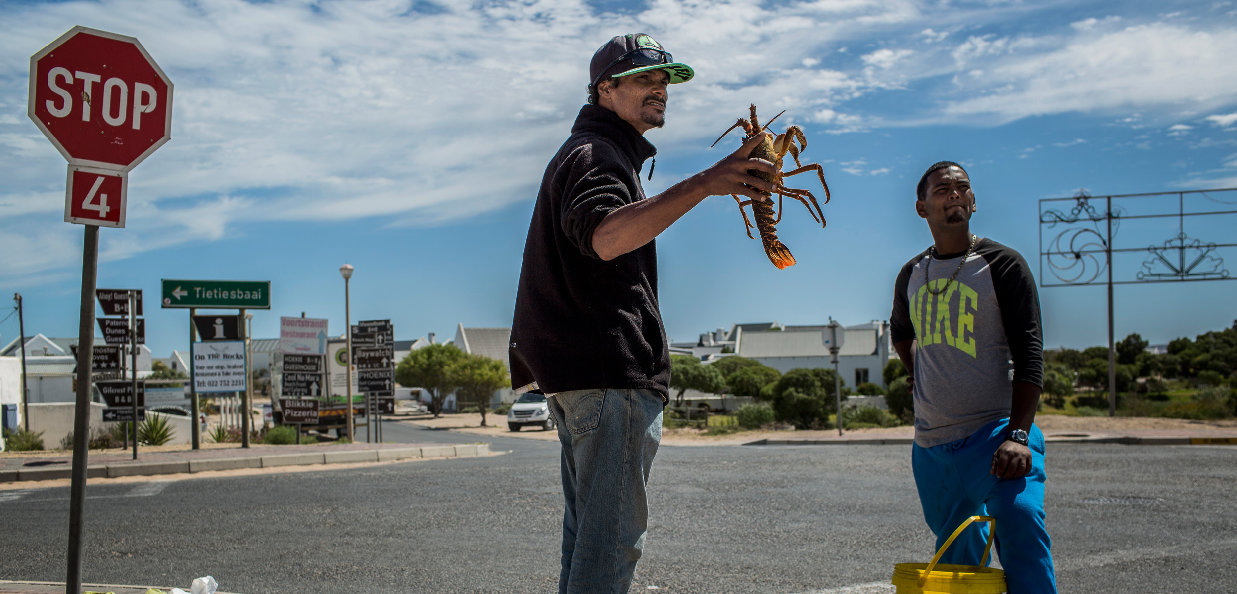 At the entrance to Paternoster, South Africa, men openly sell illegally harvested crayfish. Photo by Charlie Shoemaker