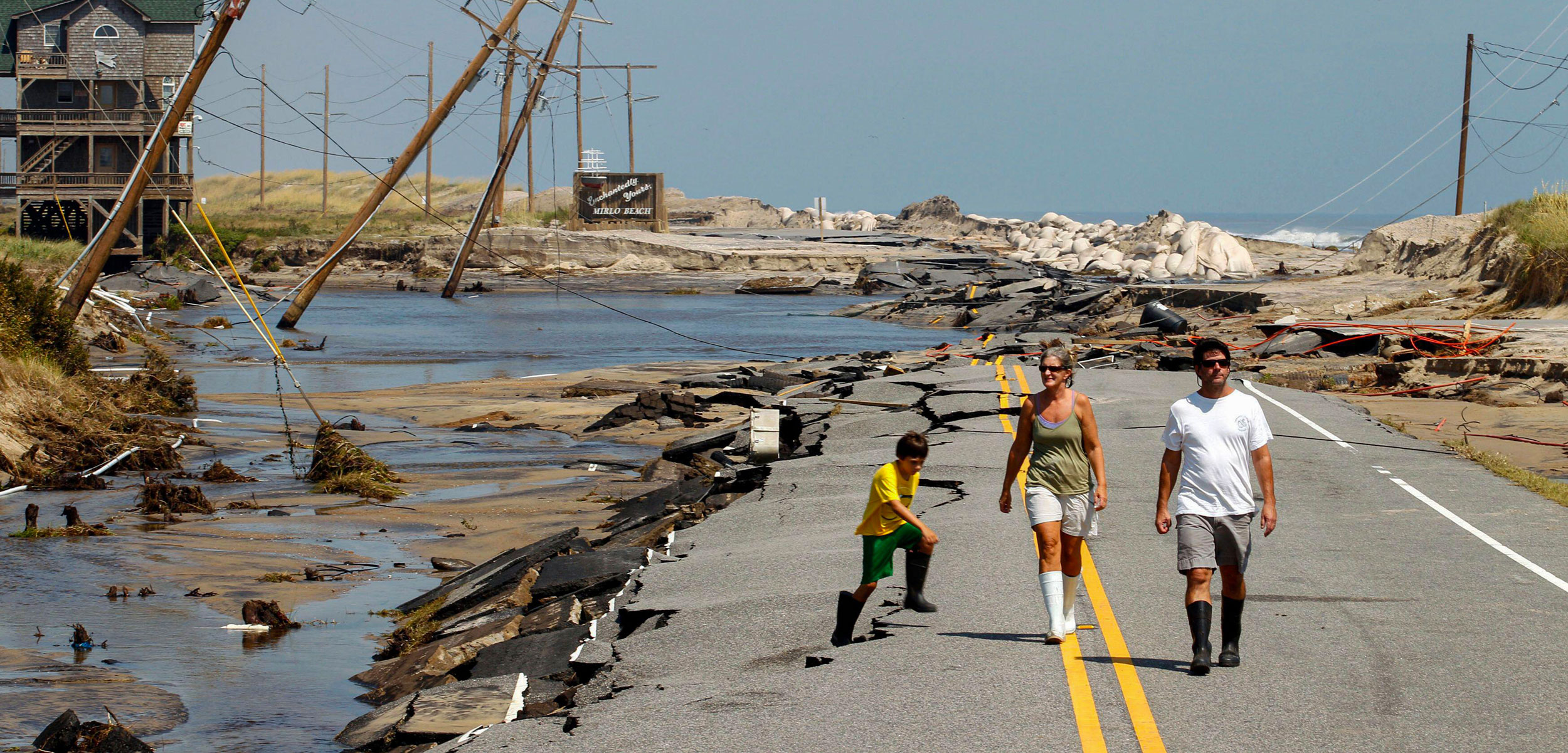 Residents walk along a highway in North Carolina after it was destroyed by Hurricane Irene