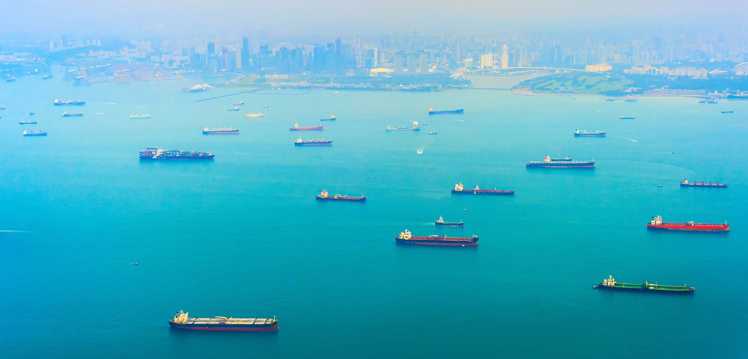 Aerial view of Singapore harbor with cargo ships, city in the background
