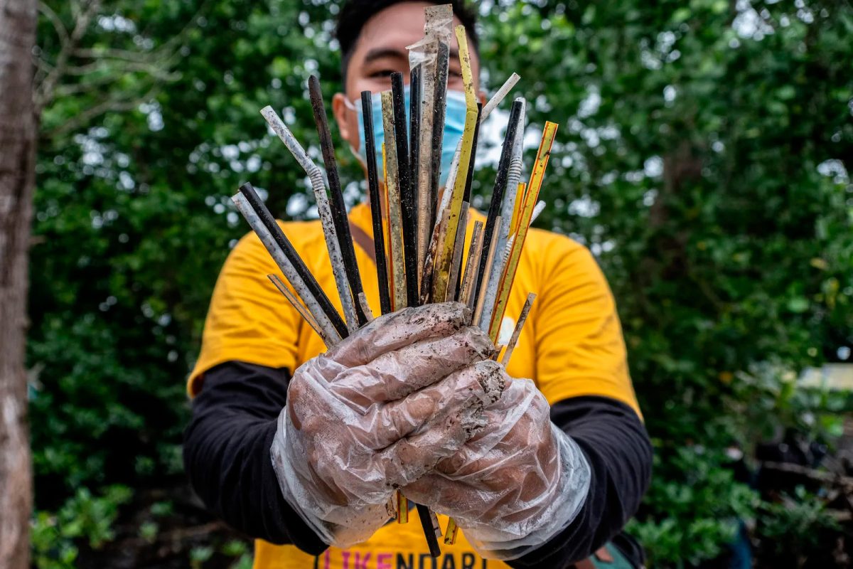 A volunteer holds plastic straws picked during the World Cleanup day
