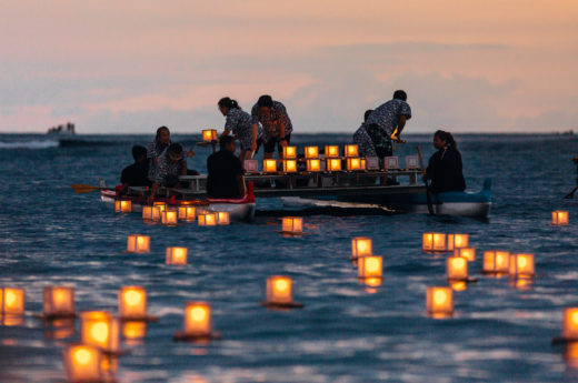 Volunteers in outrigger canoes place candlelit lanterns in the shallow waters off O‘ahu’s Ala Moana Beach as part of the Lantern Floating Hawaii ceremony. Photo by Logan Mock-Bunting/Corbis