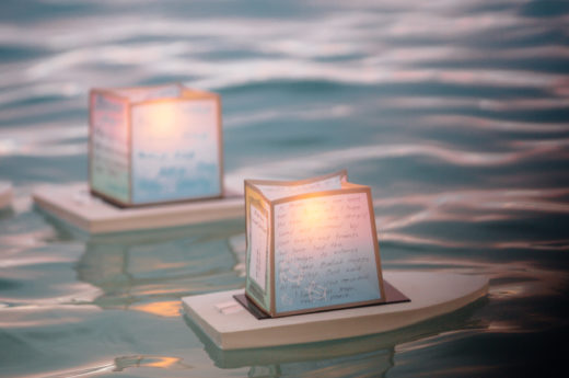 Candlelit lanterns on small boats bear handwritten messages of love and remembrance for those who have died. Photo by Logan Mock-Bunting/Corbis