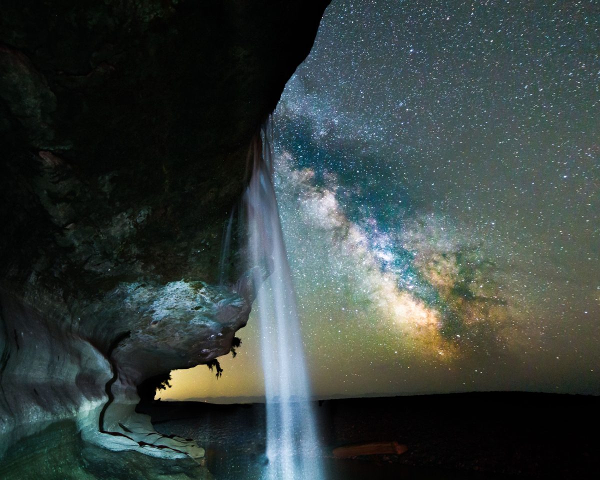 the milky way with a waterfall in the foreground