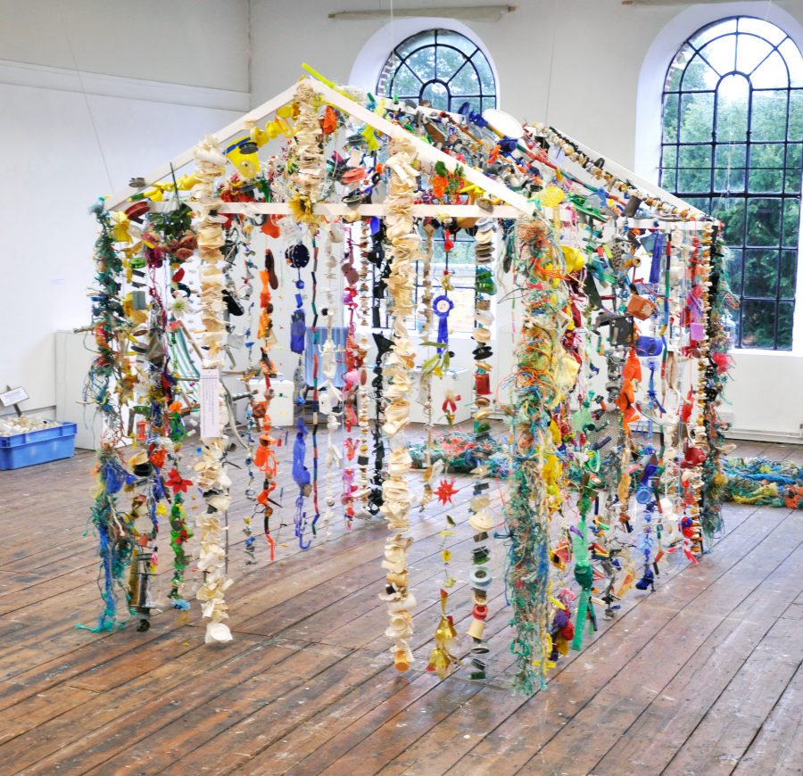 Garlands of unwashed plastic beach debris form the Oil Age Hut installation. Photo courtesy of Fran Crowe