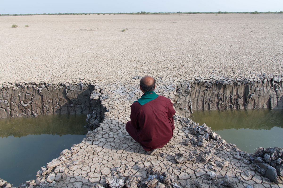 man siting between water filled holes