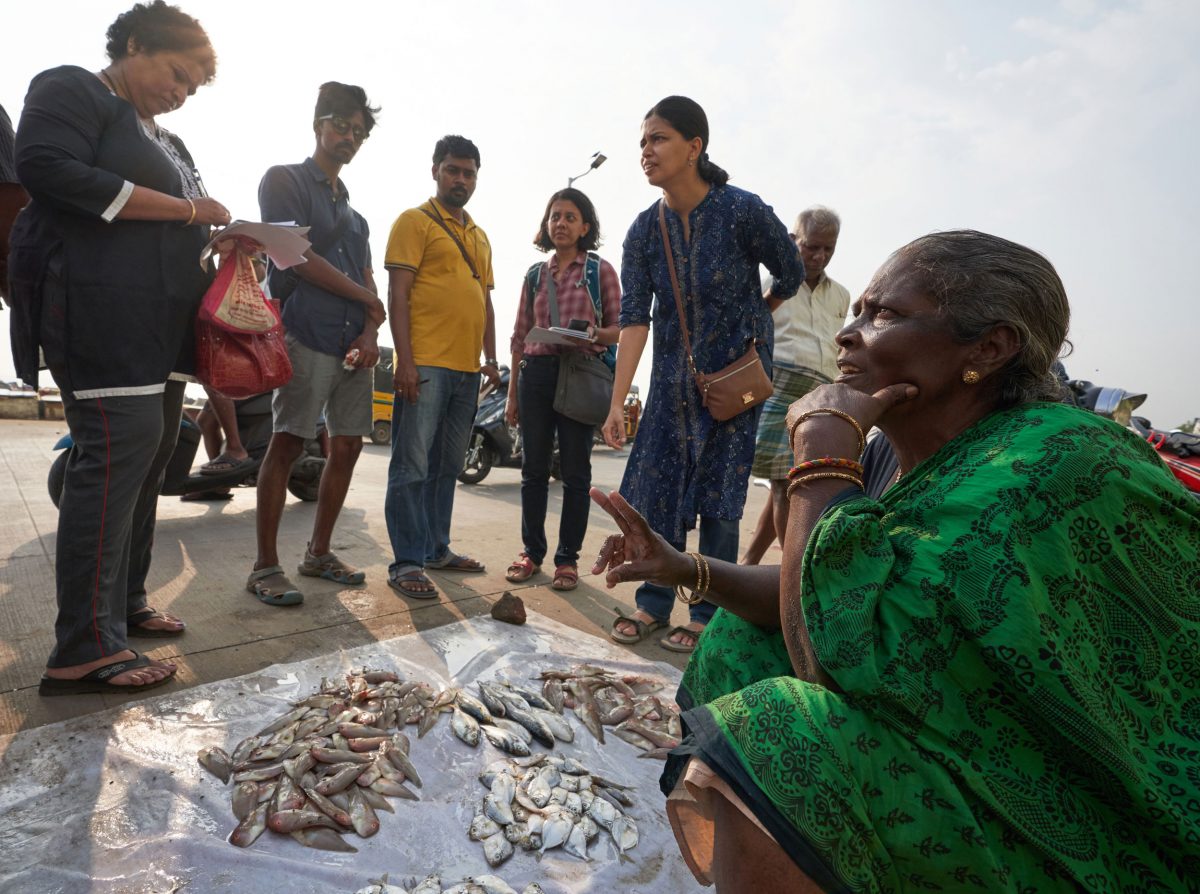 A fish vendor at Marina Beach, in Chennai, India, discusses her offerings with Fishploration participants