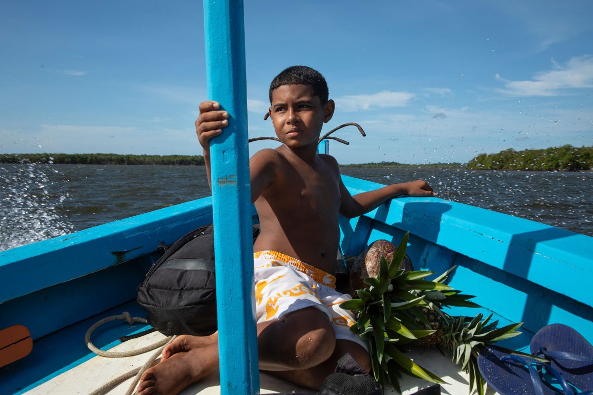 Rubens Menezes de Souza’s son sits at the bow of the family boat