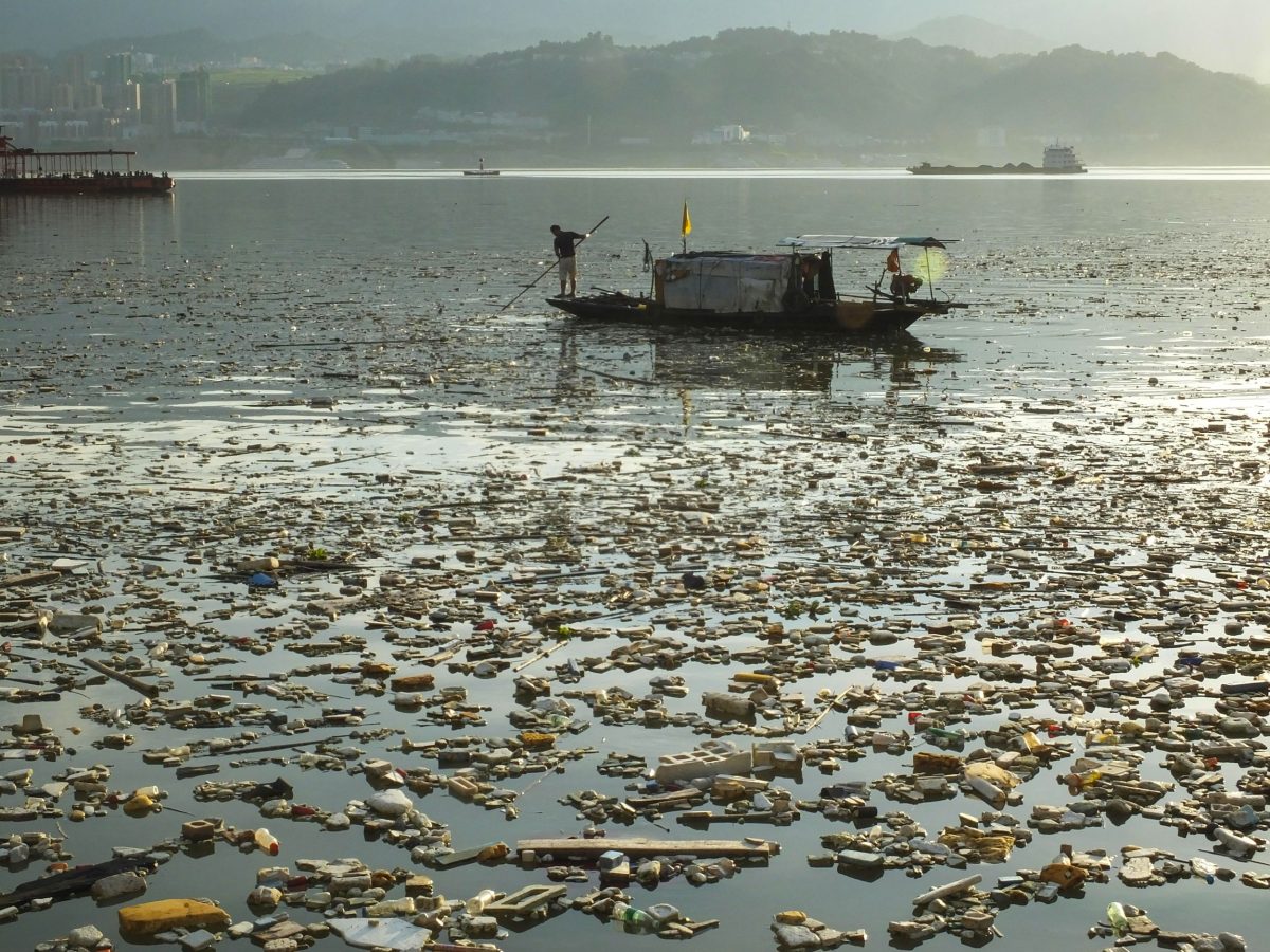 A Chinese worker collects garbage floating on the Yangtze River